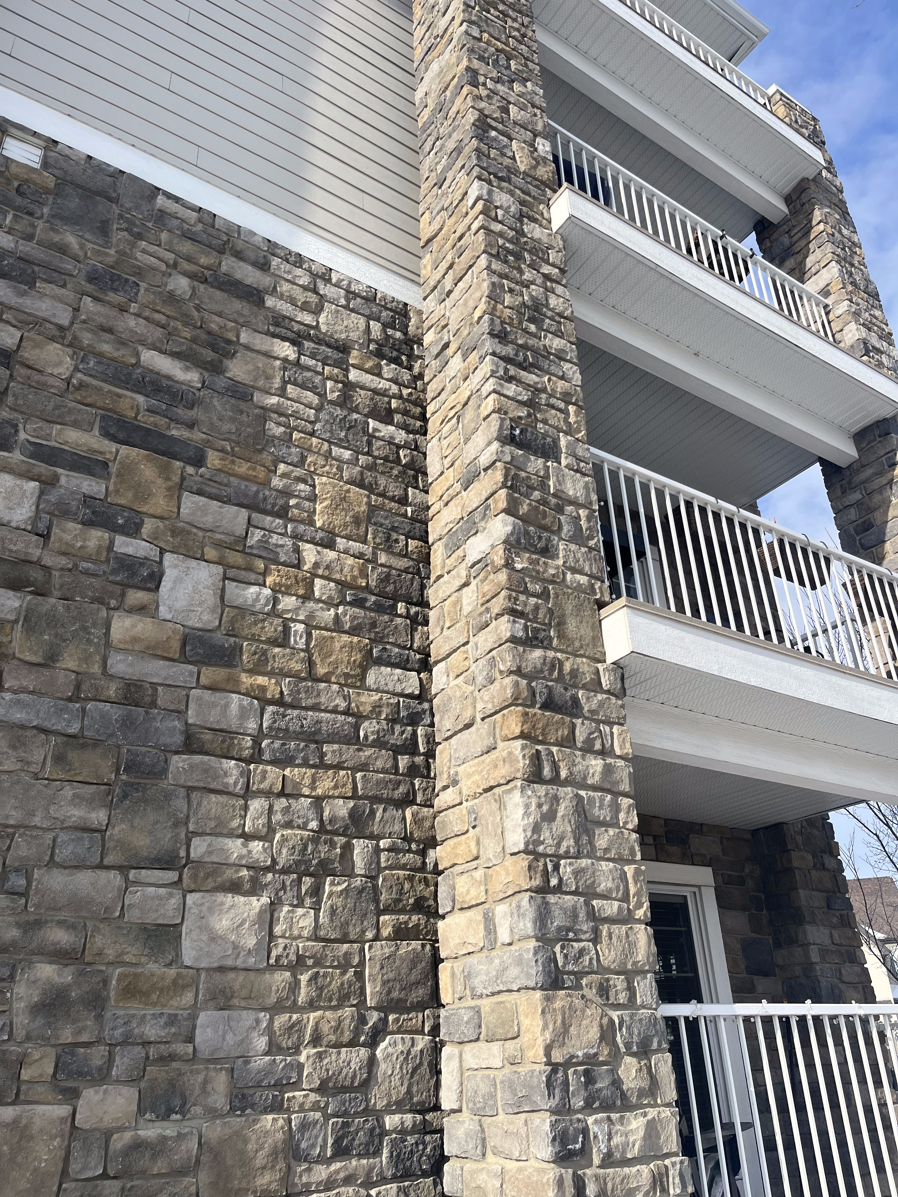 Multi-tone stone veneer wrapping an apartment building column