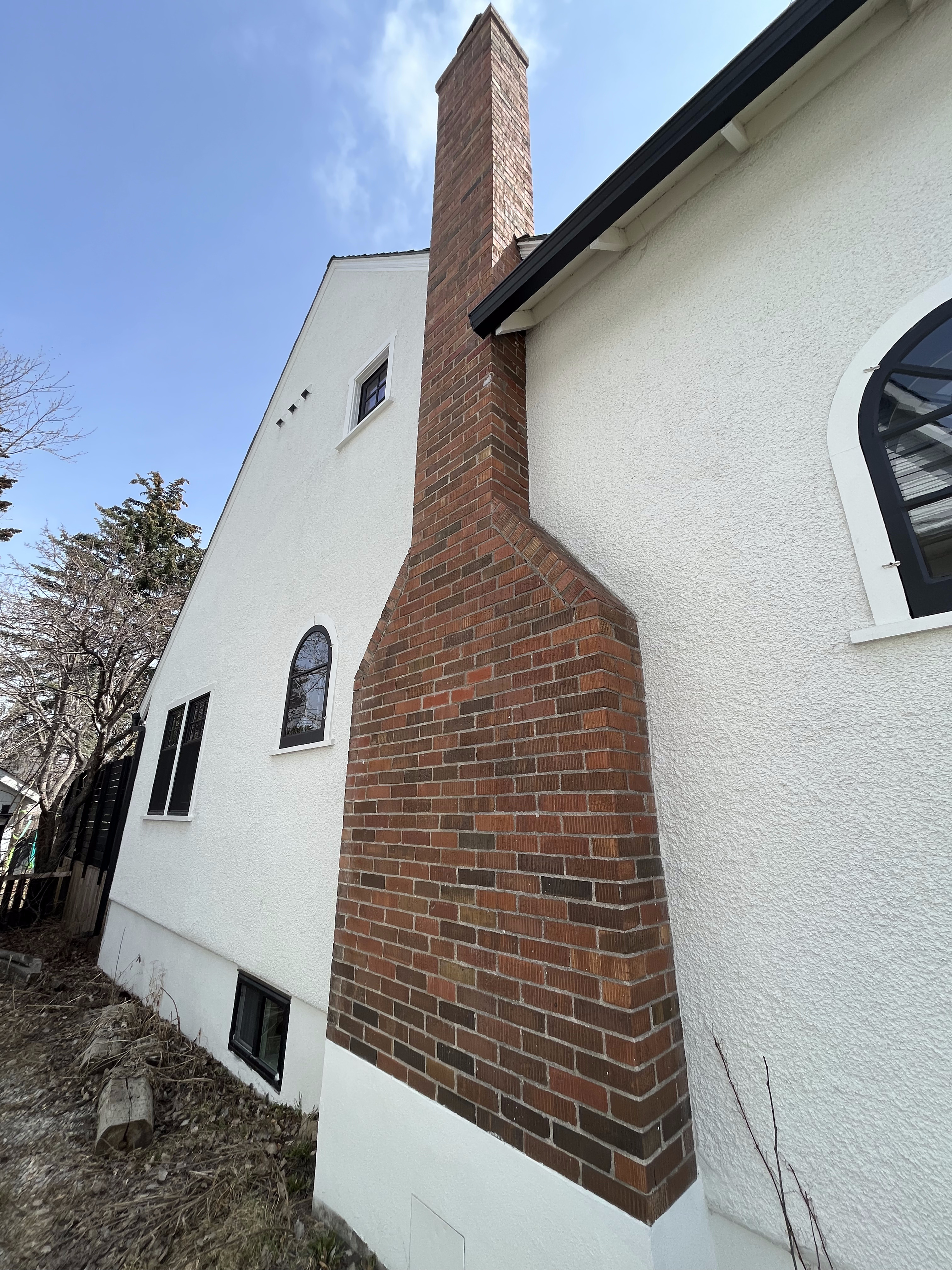 Red brick chimney on a stucco-finished house in Calgary