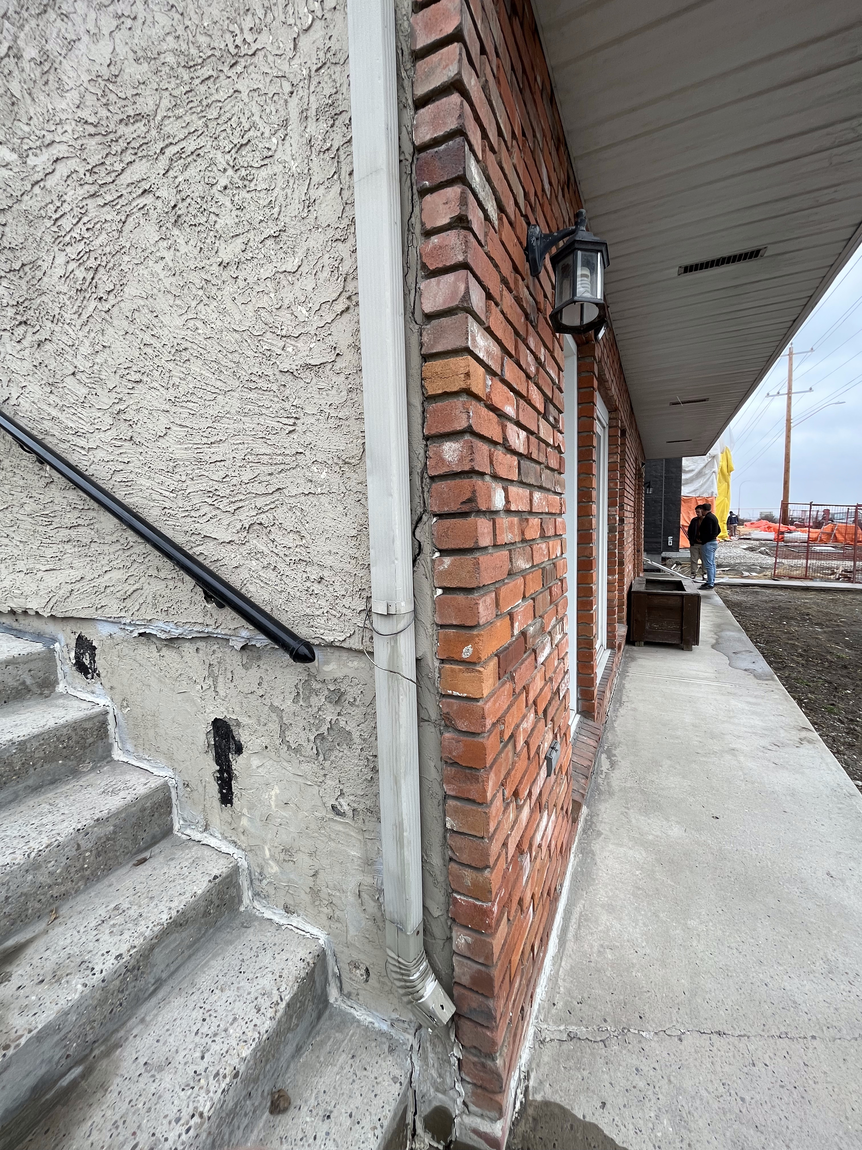 Red brick wall and stucco foundation on the side of a home